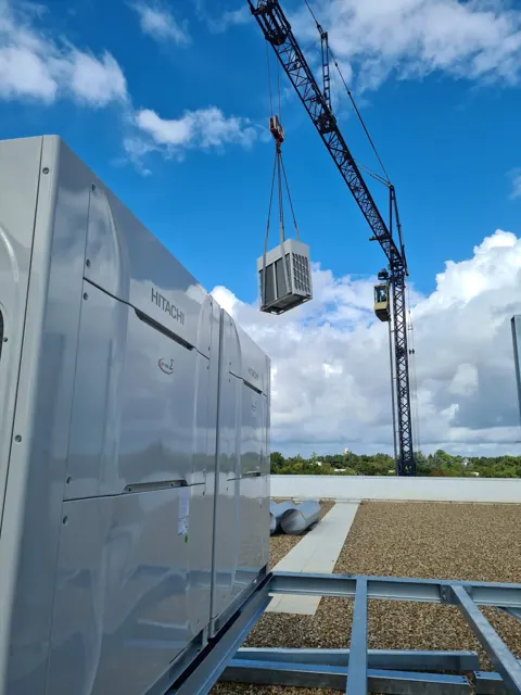 Grutage d'un groupe Hitachi sur la toiture d'un immeuble de bureaux à Pessac