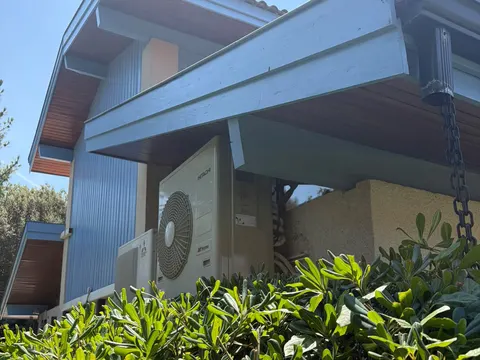 Groupe extérieur Hitachi de quadri-split sous un avant-toit, maison à Arcachon