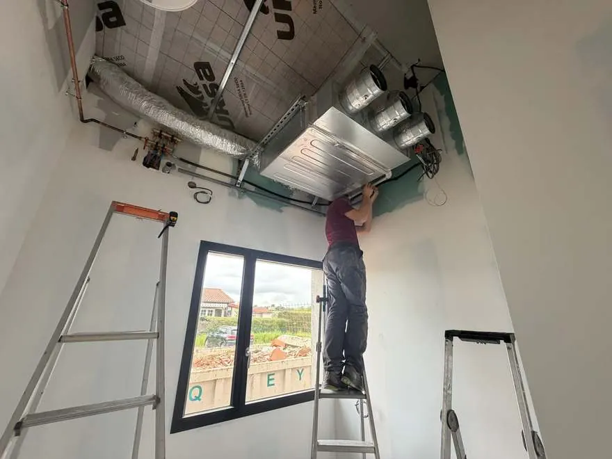 Technicien NJ Concept sur une échelle lors de la pose d'une unité gainable