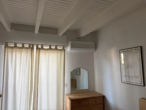 Split mural discret dans une chambre à poutres apparentes