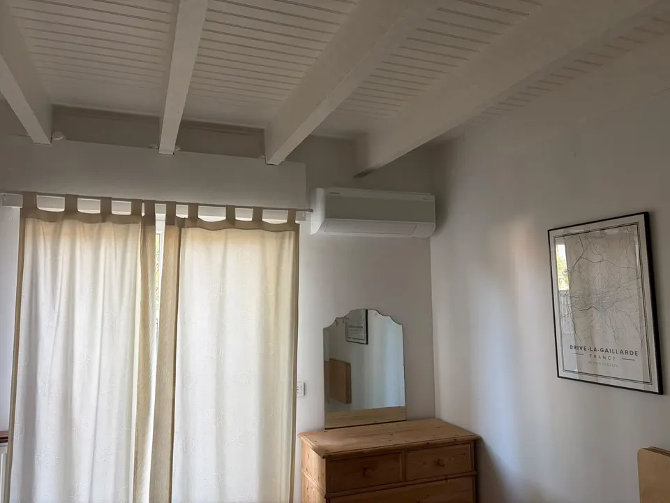 Split mural discret dans une chambre à poutres apparentes